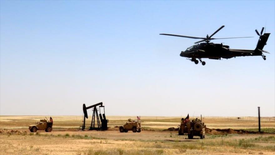 Un helicóptero de ataque AH-64 Apache del Ejército de EE.UU. durante una misión en un campo de petróleo sirio.