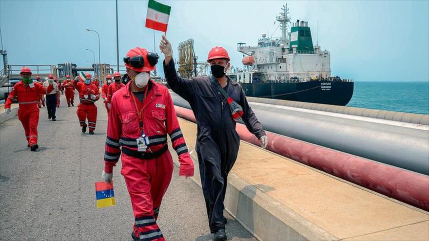 Un trabajador venezolano ondea una bandera iraní celebrando la llegada del petrolero iraní Fortune a una refinería venezolana, 25 de mayo de 2020. (Foto: AFP)