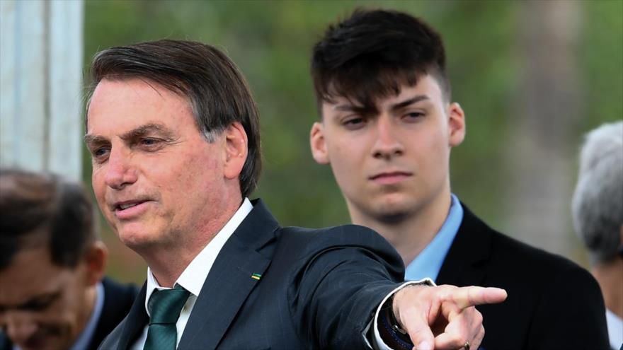 El presidente brasileño, Jair Bolsonaro (izda.), y su hijo menor, Renan Bolsonaro. (Foto: AFP)