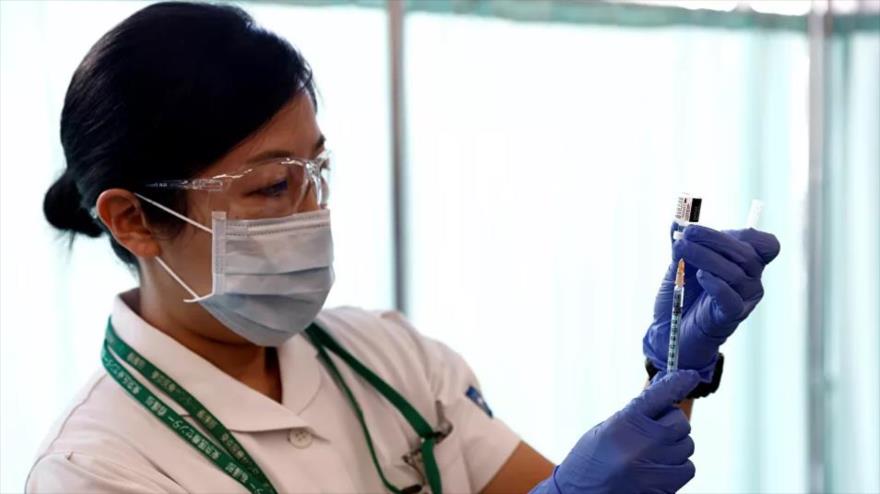 Una enfermera japonesa se prepara para inocular con una dosis de la vacuna contra la COVID-19 a un paciente en un centro hospitalario. 
