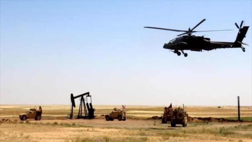 Un helicóptero de ataque AH-64 Apache del Ejército de EE.UU. durante una misión en un campo de petróleo sirio.
