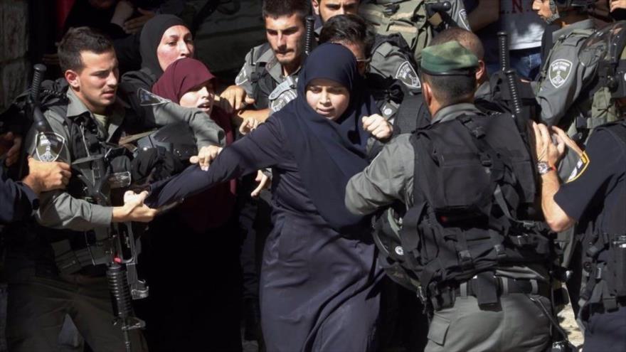Agentes de la Policía de Fronteras de la ocupación israelí detienen a una mujer palestina. (Foto: Wafa News Agency)