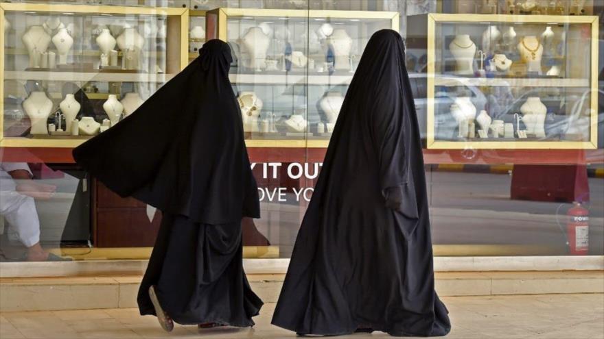 Dos mujeres saudíes pasan a los joyeros en un mercado de oro en Riad, capital de Arabia Saudí, 30 de abril de 2020. (Foto: AFP)