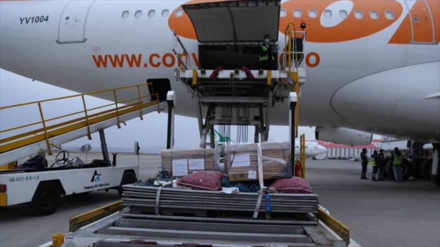 Un operario iraní descarga pallet de dosis de vacuna conjunta Irán-Cuba para la COVID-19, en el Aeropuerto Internacional Imam Jomeini de Teherán, 11 de marzo de 2021.