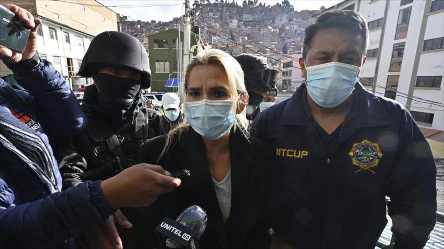 La expresidenta de facto de Bolivia, Jeannine Áñez, es escoltada por los policías luego de ser arrestada en La Paz, 13 de marzo de 2021. (Foto: AFP)