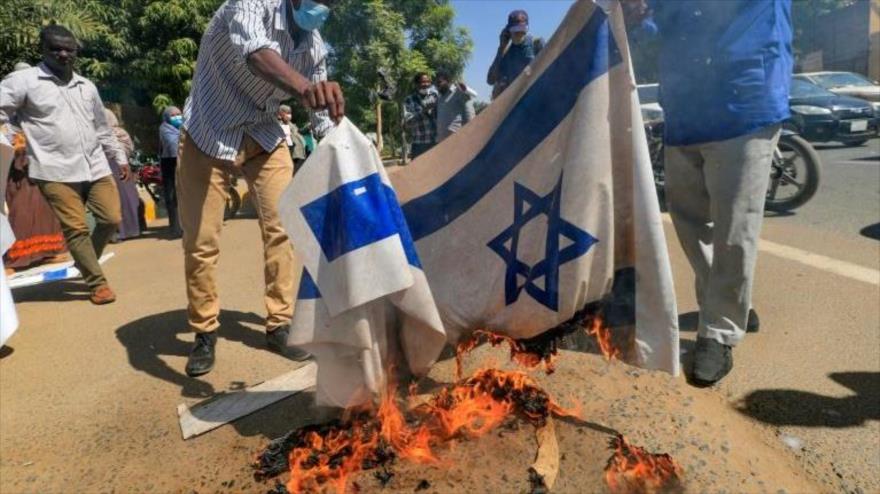 Sudaneses queman la bandera israelí en una protesta en Jartum, la capital, 17 de enero de 2021. (Foto: AFP)