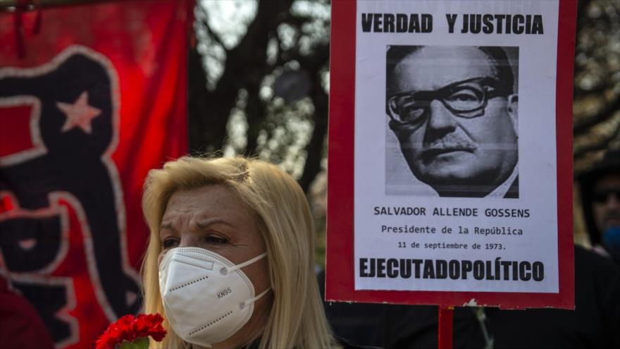 Una mujer sostiene un cartel con la imagen del expresidente chileno Salvador Allende en Santiago, capital, 11 de septiembre de 2020. (Foto: AFP)