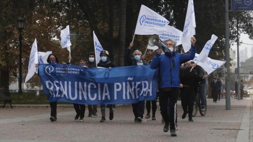 Habitantes de la capitalina ciudad de Santiago portando una pancarta en la que piden la renuncia del presidente Sebatián Piñera. (29 de abril de 2021)