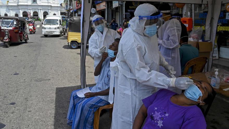 Trabajadores de salud recolectan muestras de hisopos de los residentes para realizar pruebas del coronavirus en Sri Lanka, 4 de mayo de 2021. (Foto: AFP)