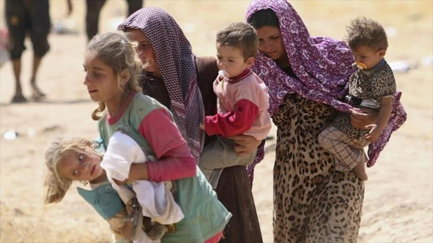 Mujeres izadíes con sus hijos en brazo tratan de huir las violencias del grupo terrorista Daesh en Irak.
