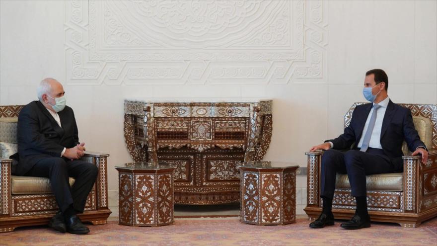 El presidente sirio, Bashar al-Asad (dcha.), y el canciller iraní, Mohamad Yavad Zarif, en Damasco, capital de Siria, 12 de mayo de 2021. (Foto: SANA)