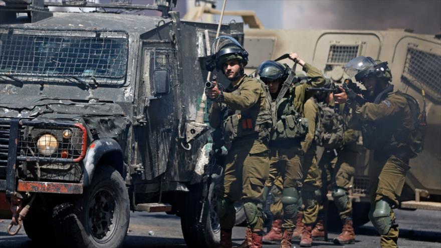 Las fuerzas israelíes disparan botes de gas lacrimógeno contra manifestantes palestinos en la ocupada Cisjordania, 14 de mayo de 2021. (Foto: AFP) 