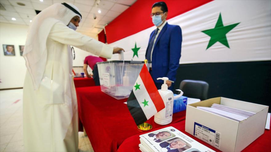 Un ciudadano sirio emite su voto para las elecciones presidenciales en la embajada siria en la ciudad de Kuwait, 20 de mayo de 2021. (Foto: AFP)