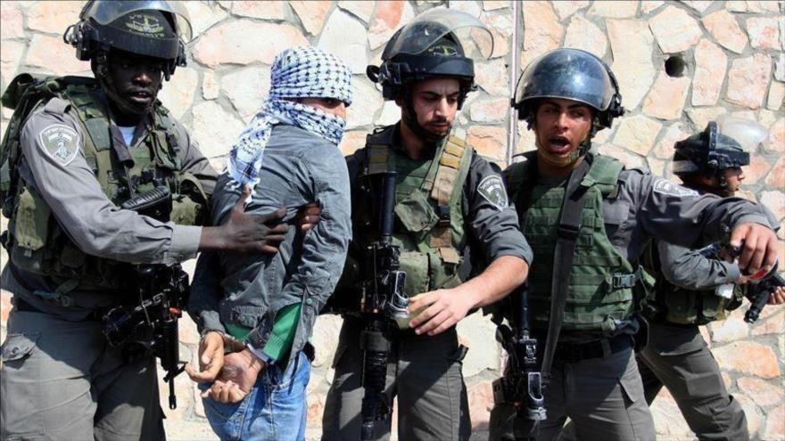 Las fuerzas del régimen israelí detienen a un joven palestino en la ciudad de Al-Quds (Jerusalén).