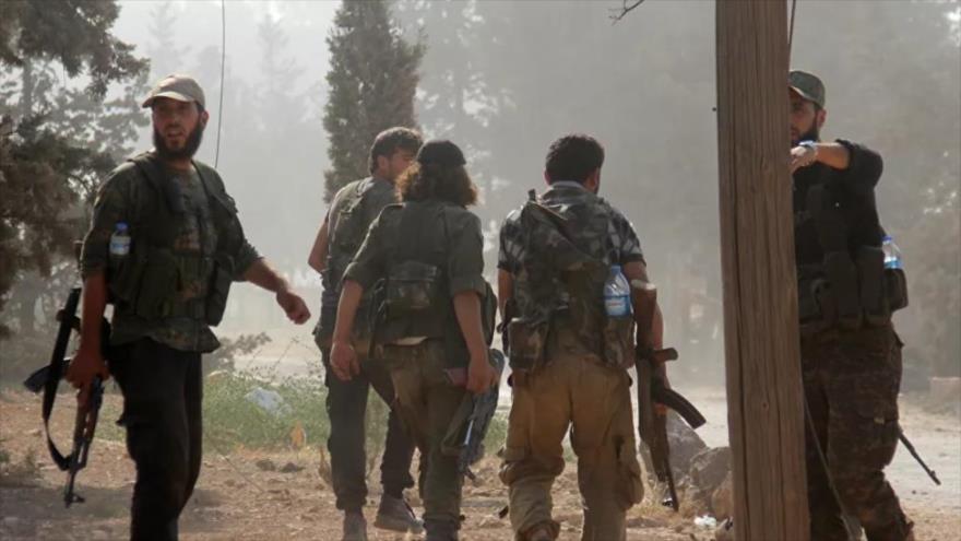 Terrorista del Frente Al-Nusra pasan por una academia militar en la provincia siria de Idlib, 6 de agosto de 2016.