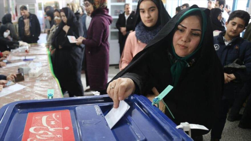 Una mujer iraní deposita su voto en un colegio electoral de Teherán (capital) durante elecciones parlamentarias, 20 de febrero de 2020.