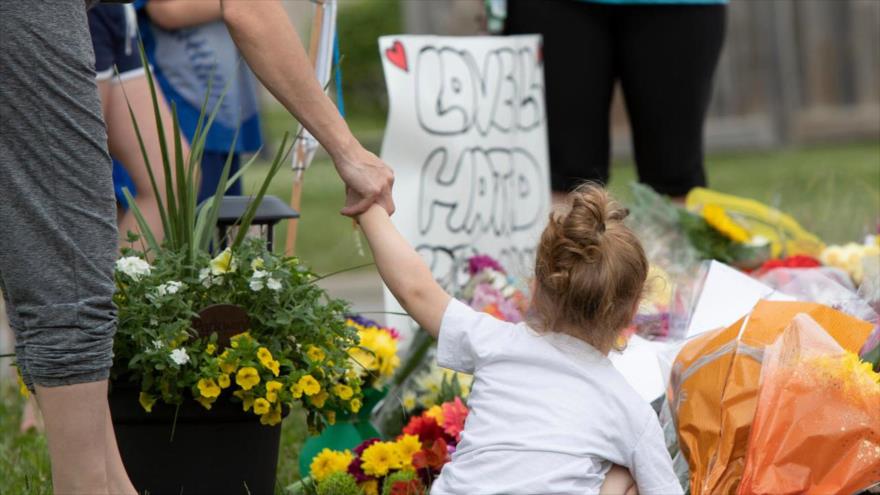 Las familias canadienses presentan sus respetos en un monumento improvisado cerca del lugar donde un hombre atropelló y mató a cuatro miembros de una familia musulmana en Ontario, 8 de junio de 2021. (Foto: AFP)