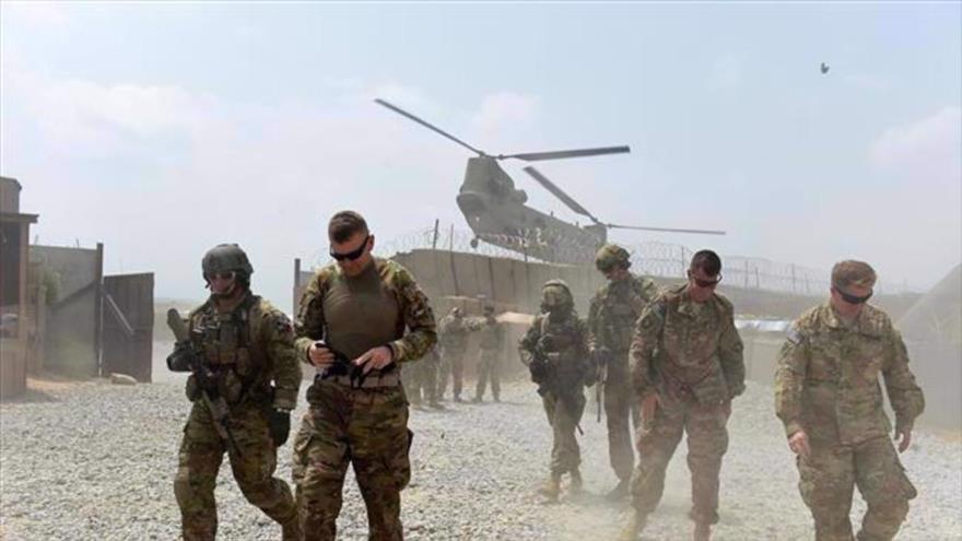 Soldados estadounidenses caminan mientras un helicóptero de la OTAN sobrevuela la provincia oriental de Nangarhar, Afganistán. (Foto: AFP)