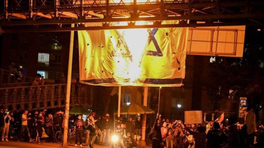 Manifestantes colombianos queman bandera israelí durante una protesta en Bogotá, la capital, 12 de junio de 2021.