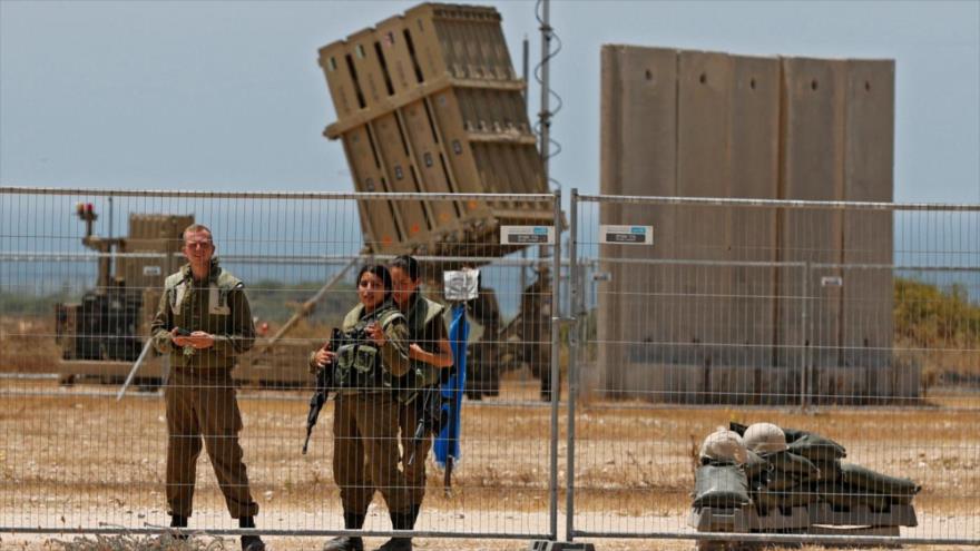 Soldados israelíes cerca de un sistema antimisiles Cúpula de Hierro en la ocupada Palestina, 11 de mayo de 2021. (Foto: AFP)