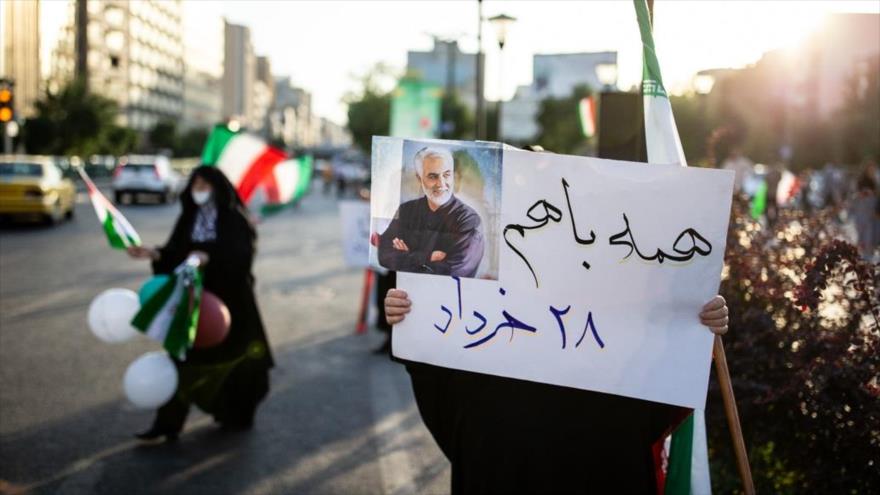 Una ciudadana iraní, mostrando una foto del general Qasem Soleimani, asesinado por EE.UU., invita a las elecciones, 15 de junio de 2021. (Foto: Fars)