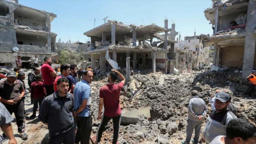 Palestinos entre los edificios destruidos por ataques de Israel.
