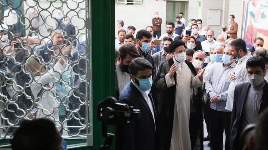 El candidato a la Presidencia de Irán Seyed Ebrahim Raisi (c) antes de emitir su voto en un colegio en Shahr-e Rey, sur de Teherán, 18 de junio de 2021. (Foto: Tasnim)
