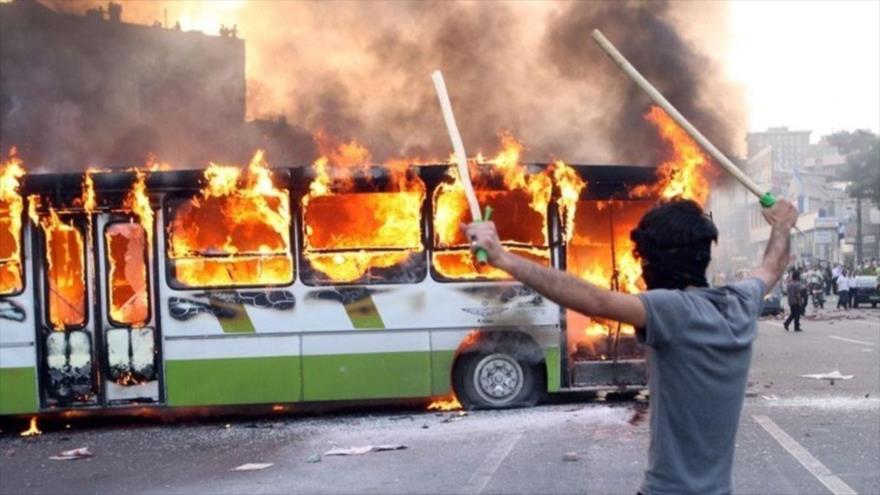 Alborotadores queman un autobús de línea durante los disturbios registrados tras las elecciones de junio de 2009 en Irán. (Foto: Tasnim)