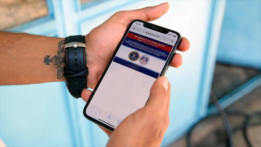 Un hombre iraní lee en su teléfono móvil una nota de bloqueo por parte de EE.UU. al sitio web de Press TV, 23 de junio de 2021. (Foto: AFP)