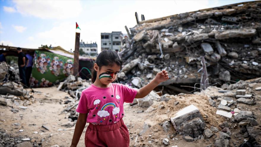 Una niña palestina juega entre los escombros de los edificios destruidos por el bombardeo israelí en la Franja de Gaza, 19 de junio de 2021. (Foto: AFP)