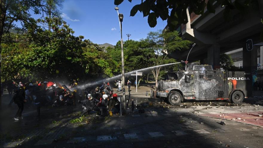 Policía colombiana ataca con cañones de agua contra manifestantes en protesta contra Gobierno en Medellín, Colombia, 28 de junio de 2021. (Foto: AFP)