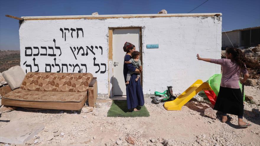 Colonos israelíes recogen sus pertenencias mientras evacuan el puesto de avanzada del asentamiento de Eviatar en Cisjordania, 2 de julio de 2021. (Foto: AFP)