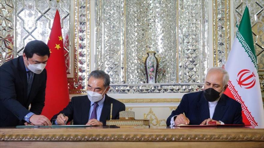 El canciller iraní, Mohamad Yavad Zarif (dcha.), y su par chino, Wang Yi, firman un acuerdo en Teherán, capital persa, 27 de marzo de 2021. (Foto: Fars)