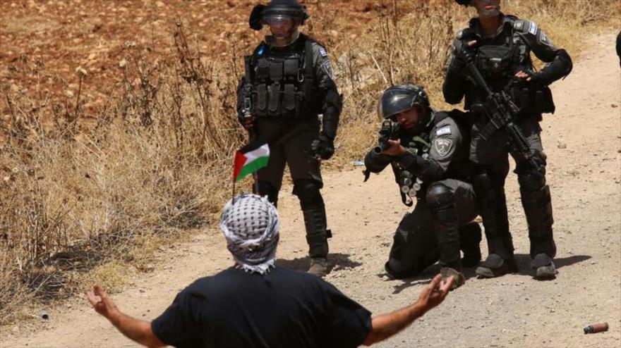 Soldados israelíes sostienen armas contra un manifestante palestino en la aldea de Beit Dajan en Cisjordania, 28 de mayo de 2021. (Foto: Xinhua )