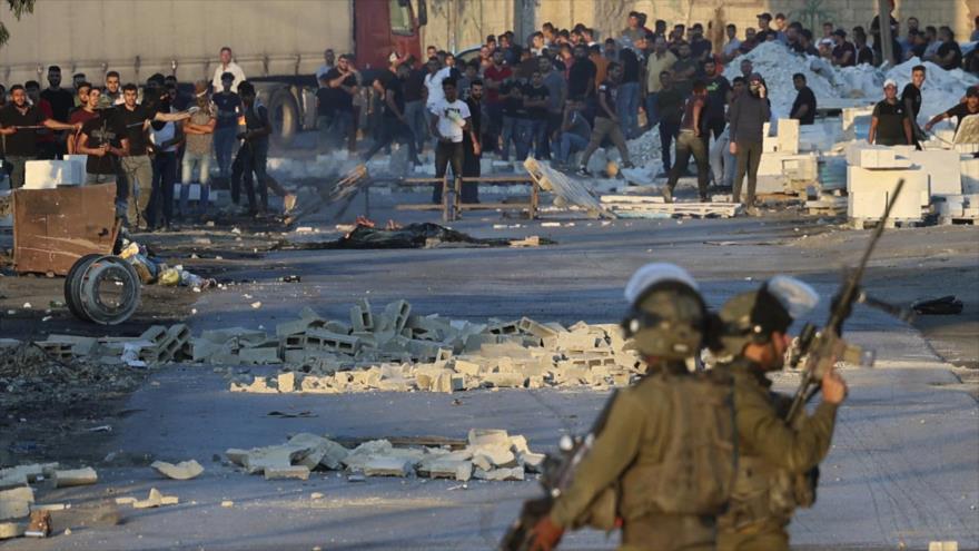 Soldados israelíes reprimen a los manifestantes palestinos en la aldea de Beita, en Cisjordania, 28 de julio de 2021. (Foto: AFP)
