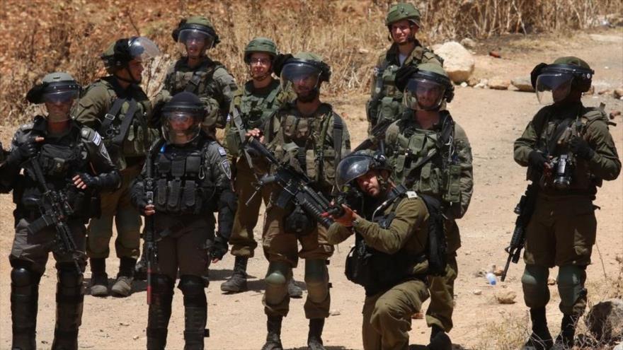 Un soldado israelí apunta con su arma a los manifestantes palestinos que protestan contra la expansión de los asentamientos judíos en la aldea de Beit Dajan, en Cisjordania, 28 de mayo de 2021. (Foto: Xinhua)