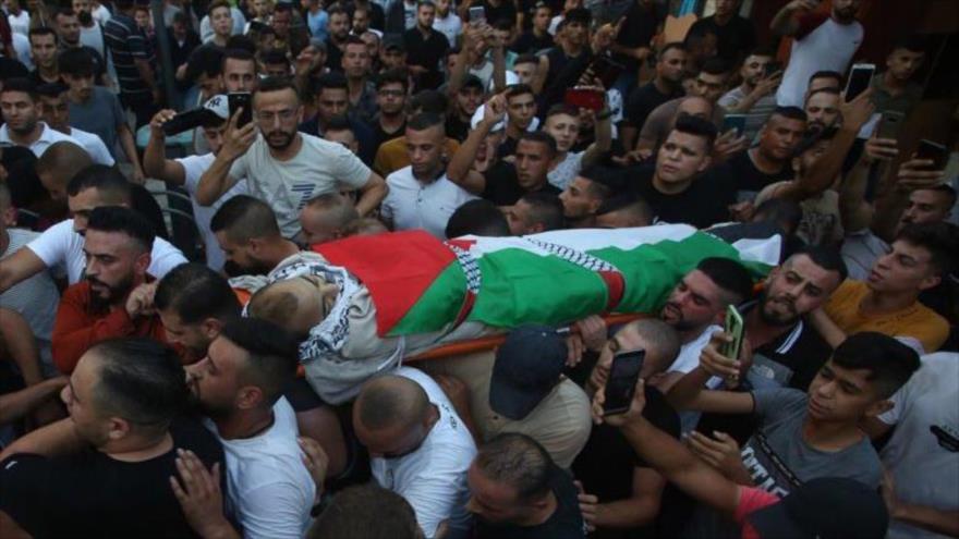 Palestinos llevan el cadáver de Dia al-Din Mohamad Sabarini, un joven palestino asesinado por tropas israelíes, 11 de agosto de 2021.
