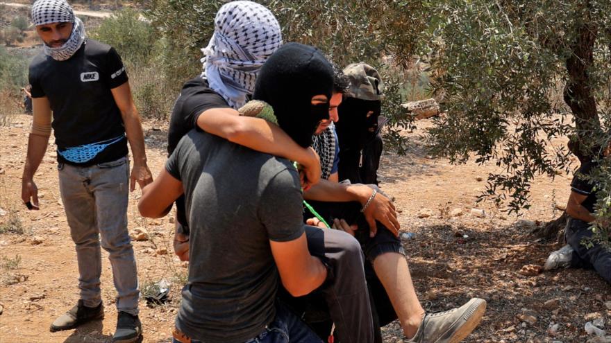 Llevan a un palestino herido en las protestas contra asentamientos israelíes en Beita, Cisjordania, 30 de julio de 2021 (Foto: AFP)