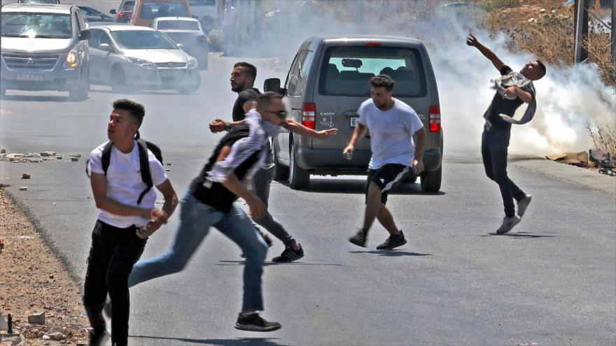 Fuerzas israelíes lanzan gas lacrimógeno contra manifestantes palestinos en la ocupada Cisjordania, 17 de agosto de 2021. (Foto: AFP)