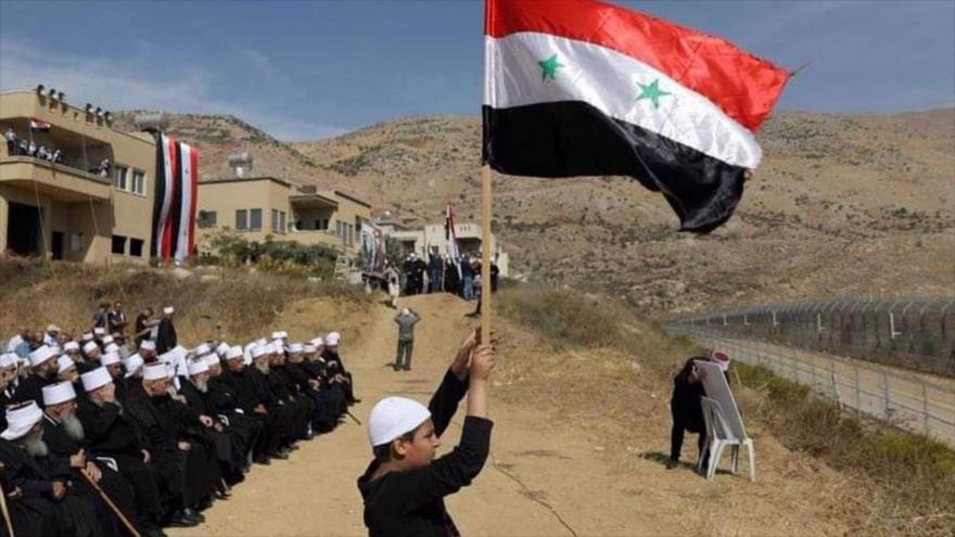 Un sirio de altos del Golán iza la bandera de Siria en señal de protesta por la ocupación de este enclave del país árabe por parte de Israel. 