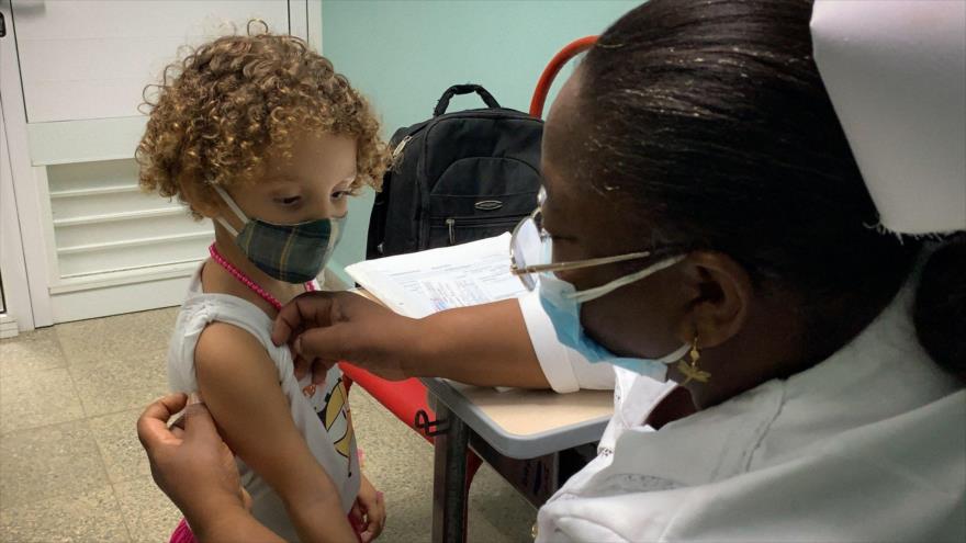 Una sanitaria cubana prepara a una niña antes de inyectar una dosis de la vacuna nacional Soberana 02 contra la COVID-19.