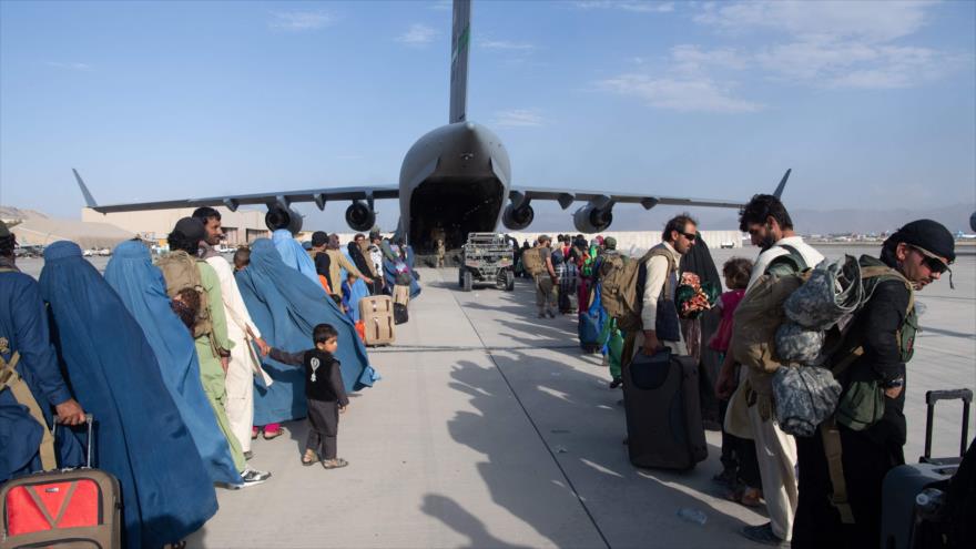 Afganos suben un avión C-17A Globemaster III en Aeropuerto Hamid Karzai de Kabul, capital, 23 de agosto de 2021. (Foto: AFP)