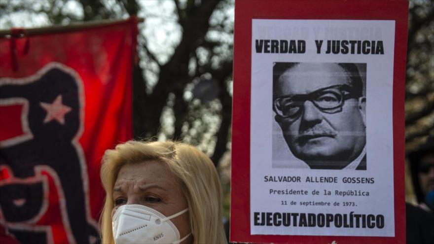 Una mujer sostiene un cartel con la foto del derrocado presidente Salvador Allende, Santiago de Chile, 11 de septiembre de 2020. (Foto: AFP)