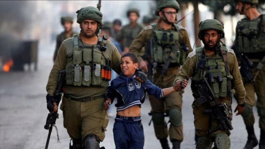 Soldados israelíes detienen a un menor palestino durante una protesta en la ocupada Cisjordania.