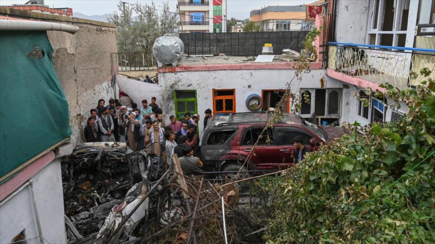 Vecinos y familiares de las víctimas se concentran en torno a un vehículo dañado tras un ataque de EE.UU. a Kabul, 29 de agosto de 2021. (Foto: AFP)