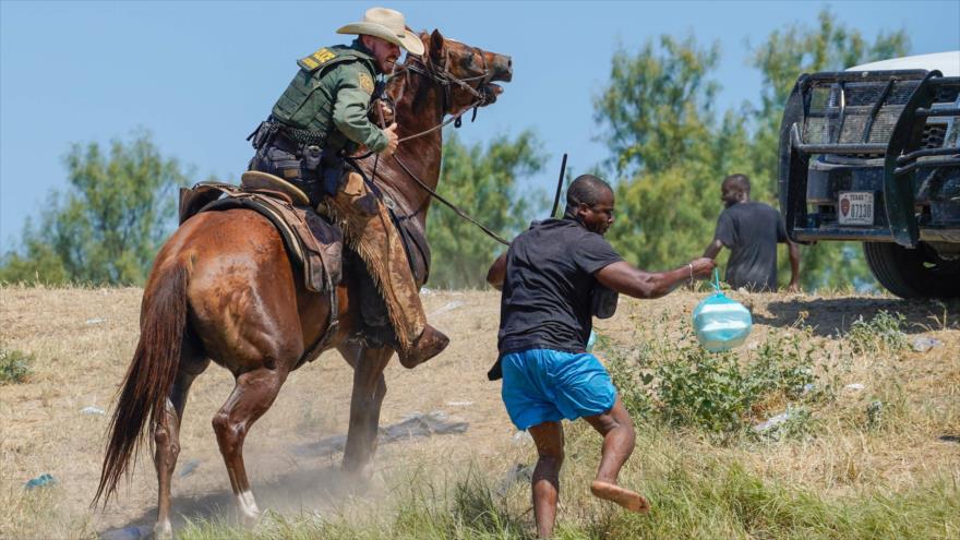 Agente fronterizo de EE.UU., montado a caballo, evita que un migrante haitiano ingrese a un campamento en Texas, 19 de septiembre de 2021. (Foto: AFP)