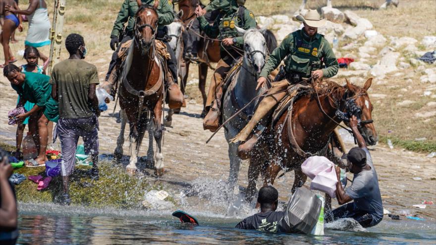 Agentes de la Patrulla Fronteriza de los Estados Unidos a caballo intentan evitar que los migrantes haitianos ingresen a un campamento, 19 septiembre de 2021. (Foto: AFP)