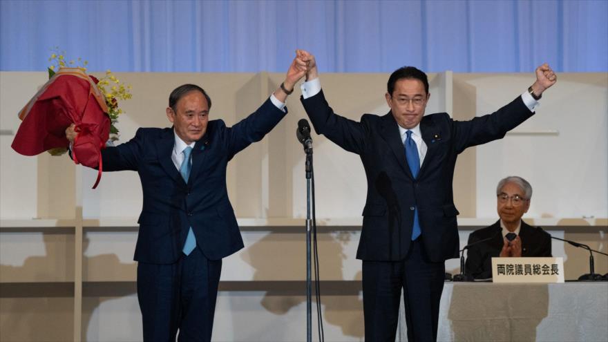 Fumio Kishida (dcha.) celebra su vitoria en las primarias del PLD junto a Yoshihide Suga, el todavía premier japonés, Tokio, 29 de septiembre de 2021. (Foto: AFP)