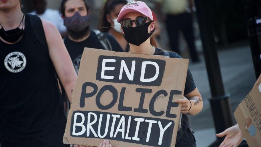 Manifestante denuncia el racismo y la violencia policial en EE.UU., con una pancarta con el eslogan “Basta con brutalidad policial”. (Foto: AFP)