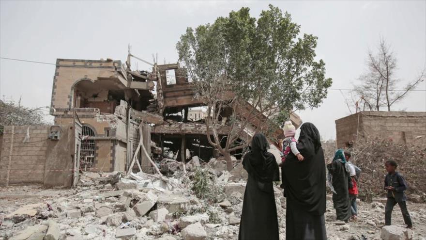 Mujeres yemeníes observan una casa destruida tras ataques aéreos de Arabia Saudí contra Saná, 6 de junio de 2018.